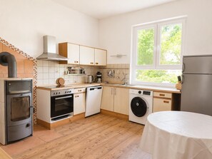 A modern kitchen with a stove, oven, dishwasher, and washing machine. - Jagels-Hammann farm, fitters' apartment, An der Schule 6, 27607 Geestland (Geestland)