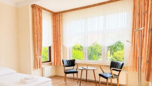 A hotel room with a bed, two chairs, a small table, and a floor lamp. - Jagels-Hammann farm, fitters' apartment, An der Schule 6, 27607 Geestland (Geestland)