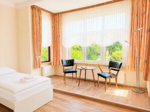 A hotel room with a bed, two chairs, a small table, and a floor lamp. - Jagels-Hammann farm, fitters' apartment, An der Schule 6, 27607 Geestland (Geestland)