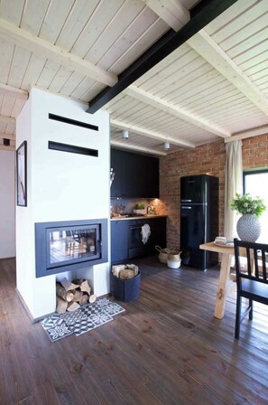 A modern kitchen with a built-in stove, dark cabinets, and a brick wall.