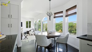 A modern kitchen with a dining area, large windows, and a chandelier. - 4BR Luxury Home with Private Pool & Jacuzzi (Los Angeles)