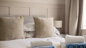 Ein Hotelzimmer mit Bett, Kissen und Handtüchern.