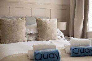 Ein Hotelzimmer mit Bett, Kissen und Handtüchern.