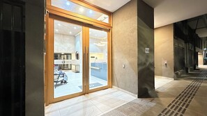 Ein Hotel mit Eingang, Glastür, einer Rezeption und einem gefliesten Boden.