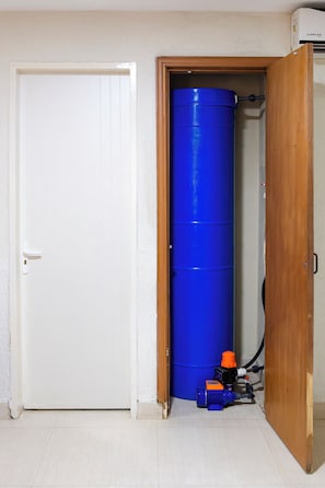 A room with a white door, a blue barrel, and a small heater. - Porlamar Work & Stay Apartment with pool and WIFI (Porlamar)