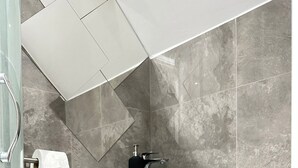 Ein Badezimmer mit Toilette, Waschbecken und Duschbereich.