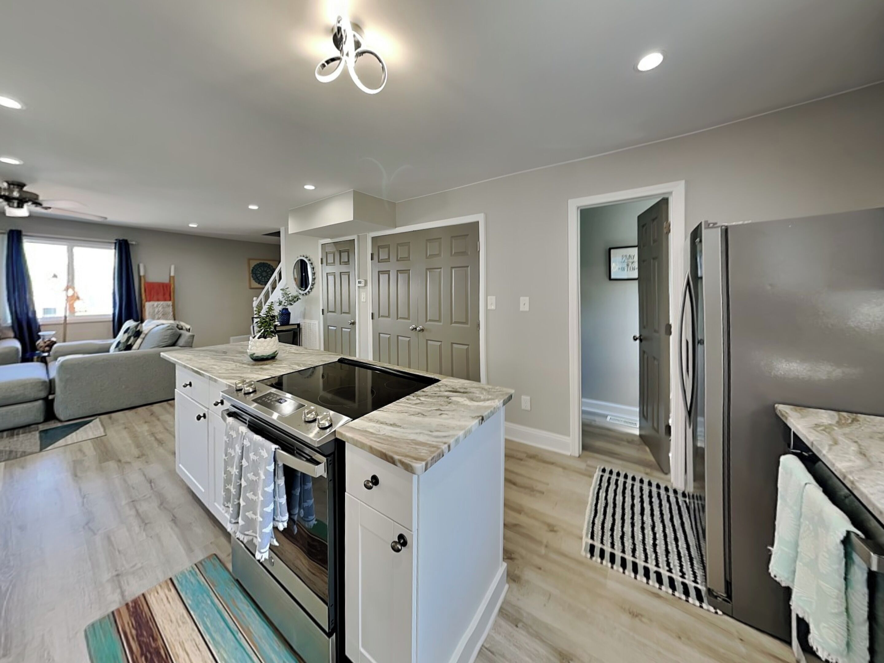 A modern kitchen with an island, built-in oven, and refrigerator.