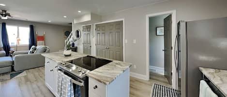 A modern kitchen with an island, built-in oven, and refrigerator.