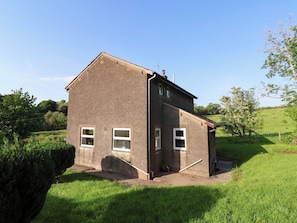A two-story house with a sloped roof, a chimney, and a small porch. - Robin Hood Farmhouse (Keswick)