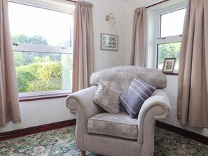 A corner room with a window, a framed picture on the wall, and a patterned carpet. - Robin Hood Farmhouse (Keswick)