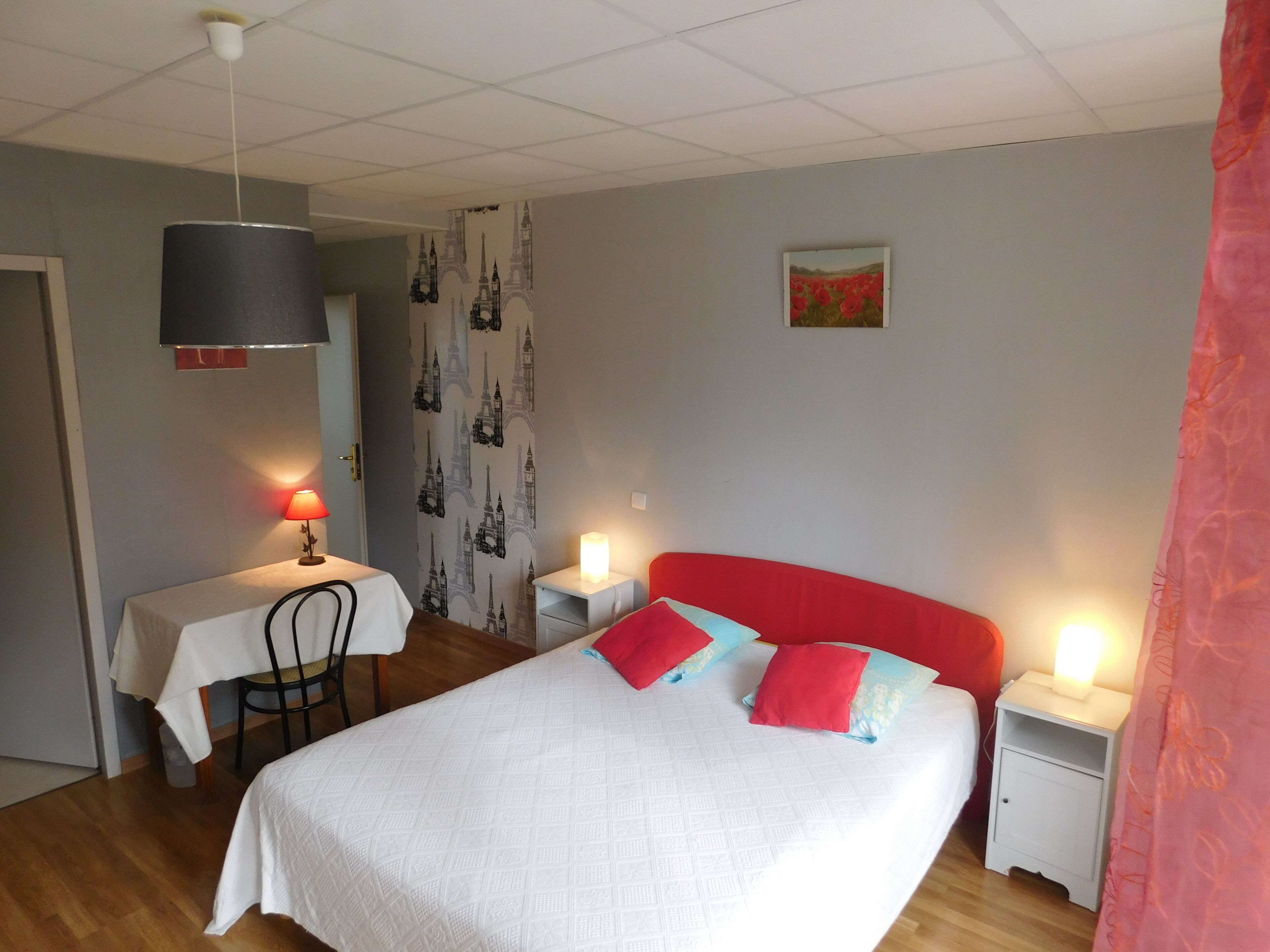 Une chambre à coucher avec un lit, des tables de chevet, un bureau et une chaise.