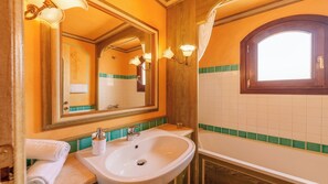 A bathroom with a sink, mirror, and light fixtures. - NG Collection Cala del Faro 206 (Arzachena)