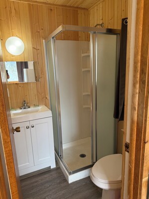 Ein Badezimmer mit Dusche, Toilette und Waschbecken.