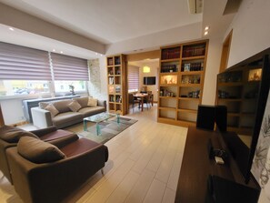 A living room with a sofa, coffee table, and bookshelves. - Andrew's House (Napoli)