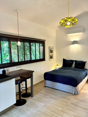 A bedroom with a bed, a desk, a chair, a window with blinds, and a pendant light. - Villa le Verger in Aix-en-Provence (Aix-en-Provence)