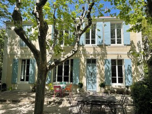 A two-story building with a patio area featuring outdoor seating and potted plants. - Villa le Verger in Aix-en-Provence (Aix-en-Provence)