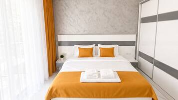 A modern hotel room with a large bed, a marble floor, and a large window with curtains.