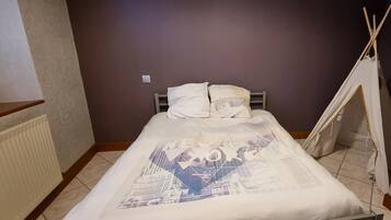 Tabla de planchar con plancha, cuna de viaje y ropa de cama