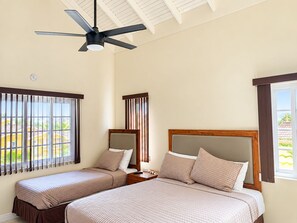 A hotel room with two beds, a ceiling fan, and large windows with blinds. - The Vista Inn Studio #2 (Falmouth)
