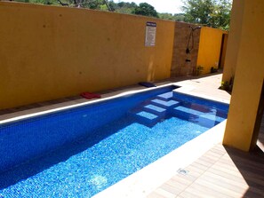 A swimming pool with a tiled edge and a sign indicating pool rules. - The Vista Inn Studio #2 (Falmouth)