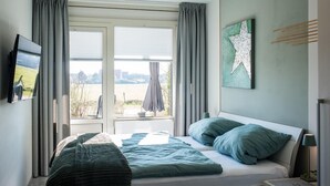 Un dormitorio con cama, cortinas, decoración de estrellas y ventana con vistas.