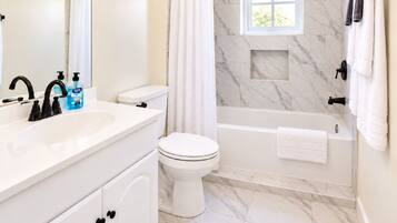 A bathroom with a white sink, toilet, and bathtub.
