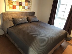 Ein Bett mit gesteppter Bettdecke, zwei Kissen und einem Kopfteil.