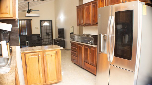 A kitchen with wooden cabinets, a stainless steel refrigerator, and a built-in oven. - The Vista Inn Suite #5 (Falmouth)