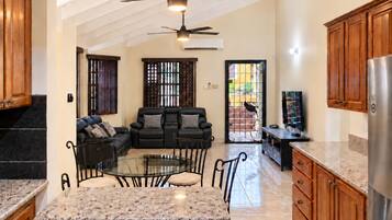 A spacious kitchen with a dining area, wooden cabinets, and a ceiling fan.