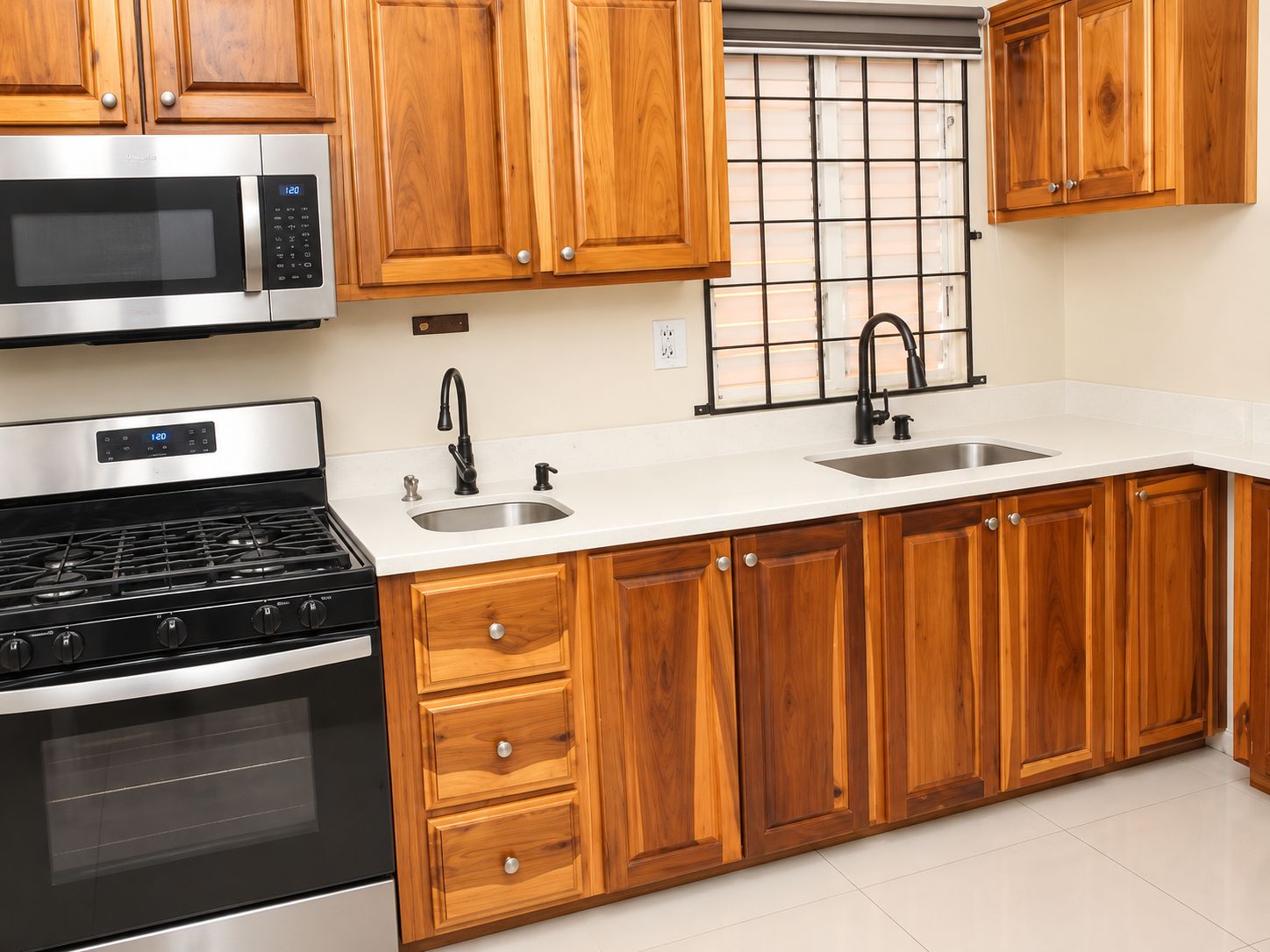 A modern kitchen with wooden cabinets, stainless steel appliances, and a double sink.