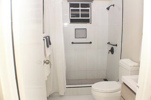 A bathroom with a shower, toilet, and sink. - The Vista Inn Suite #6 (Falmouth)