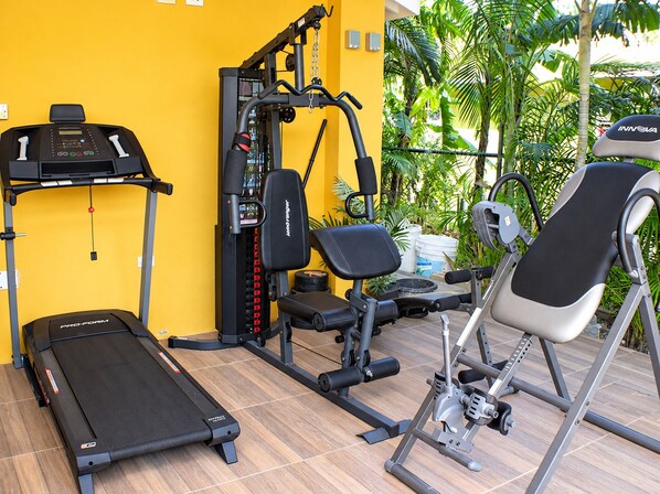 A gym with a treadmill, weight machines, and a stationary bike.