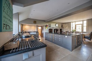 A spacious kitchen with a large island, a dining area, and a fireplace.