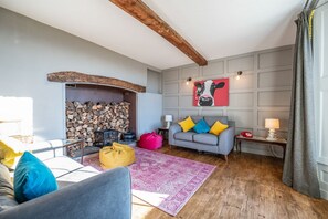 A cozy living room with a fireplace, a sofa, a coffee table, and a rug.