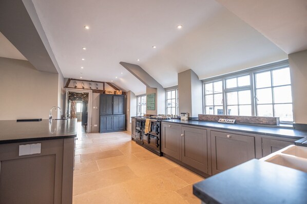 A spacious kitchen with a long countertop, built-in oven, and large windows.