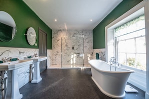 A bathroom with a freestanding bathtub, a glass-enclosed shower, and two sinks with marble countertops. - Vogel House - Six Bedroom Villa, Sleeps 14 (Llangynhafal)