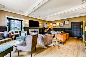 A spacious lounge area with multiple seating options, a fireplace, and a television.