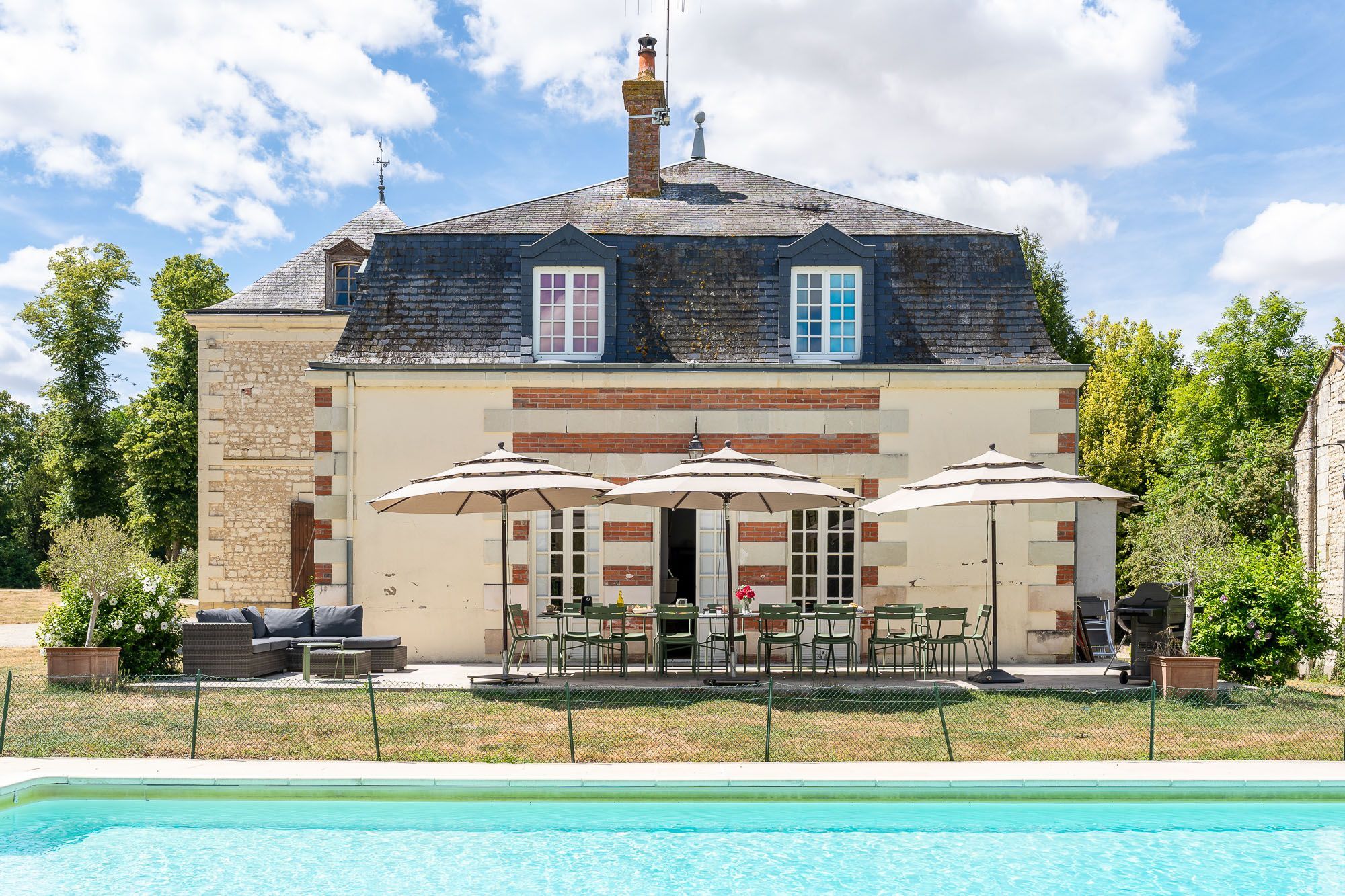 Un bâtiment à deux étages avec une piscine devant.