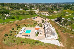 An aerial view of a property with a swimming pool, a small building, and a cluster of houses with conical roofs. - Masseria Zia Cocca - Five Bedroom Villa, Sleeps 10 (Martina Franca)