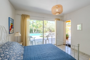 A bedroom with a bed, a window, a door leading to a balcony, and a hanging light fixture. - Villa Chautard - Four Bedroom Villa, Sleeps 8 (Tourrettes)