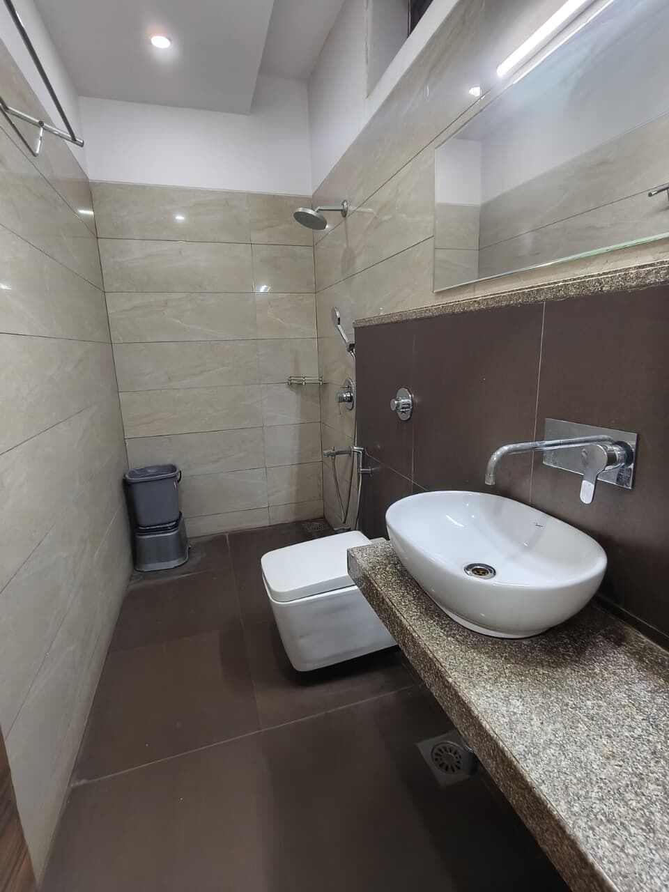 A bathroom with a white toilet, a sink with a mirror, and a shower.