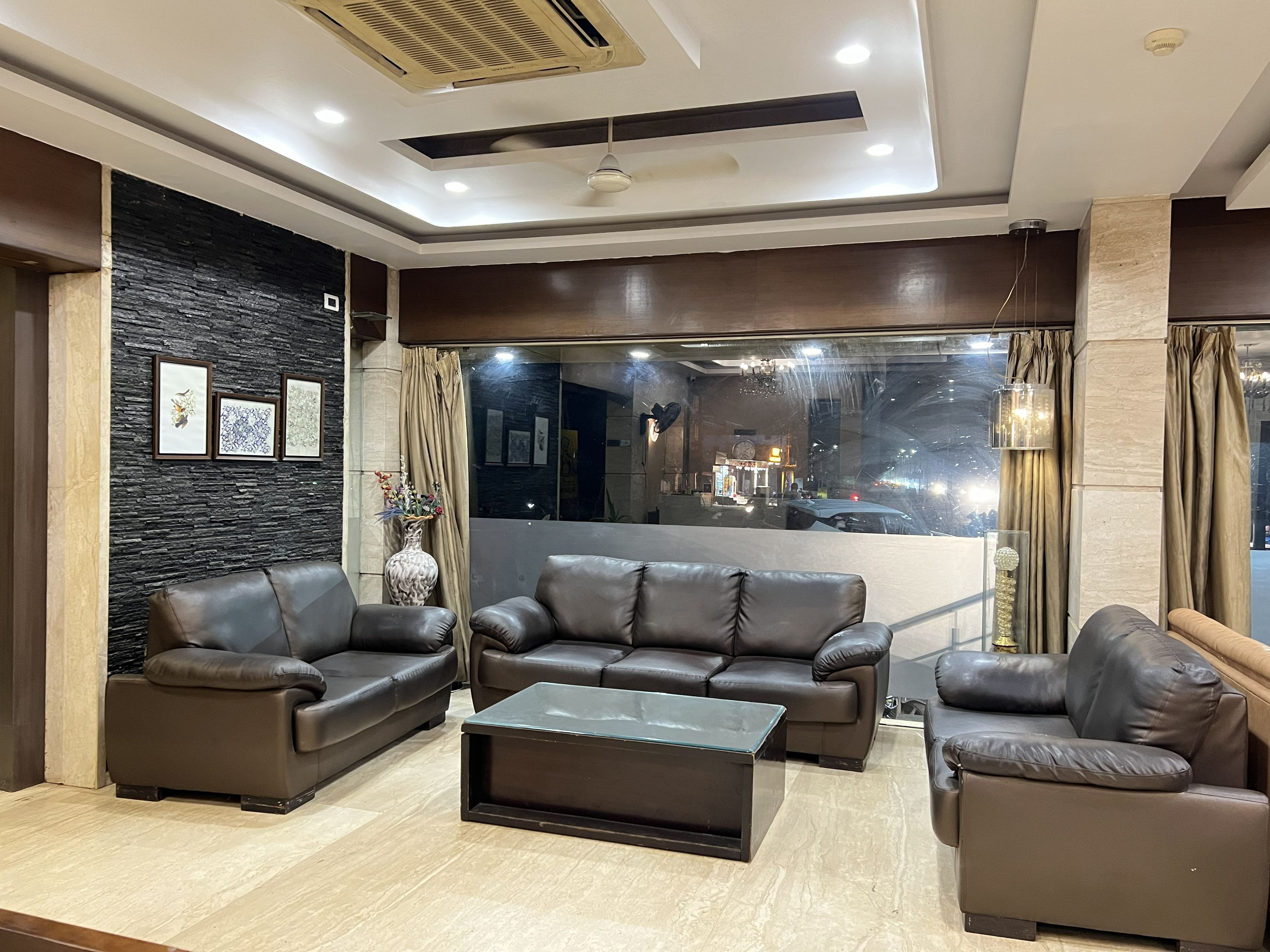 A modern living room with a sofa set, a coffee table, and a decorative vase.