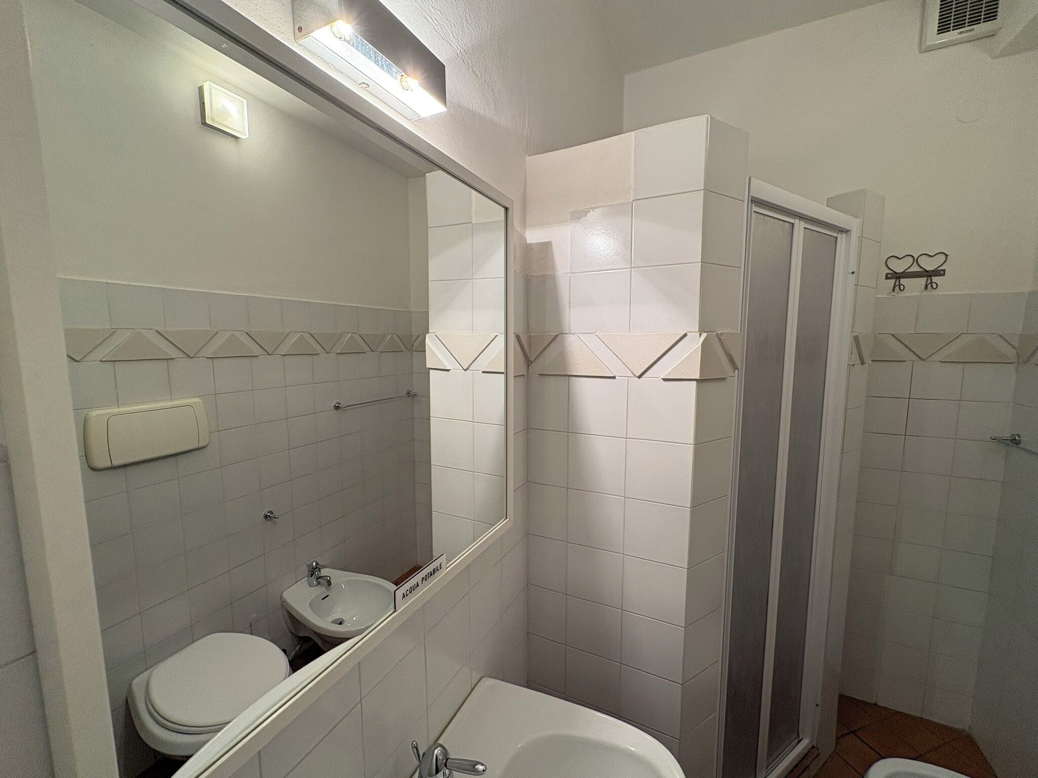 A bathroom with a toilet, sink, and shower.
