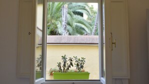 Een raam met uitzicht op een balkon, een deur en een muur.