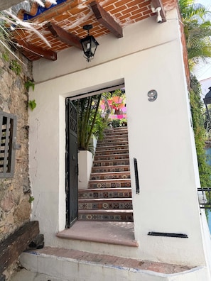 A white building with a black door and a staircase leading to the entrance. - La Casona de Los Angeles de San Juan (Taxco)