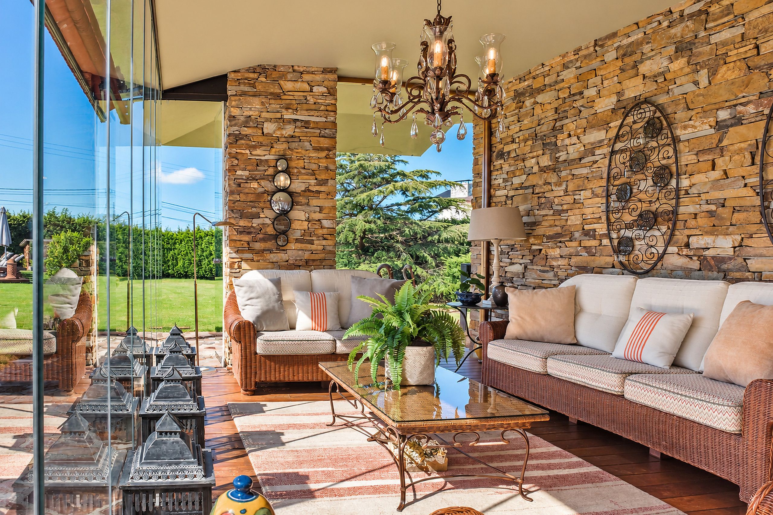 A spacious living room with a stone wall, a chandelier, a sofa, and a coffee table.