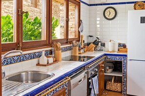 Une cuisine équipée d’un évier, d’une cuisinière et de divers ustensiles.