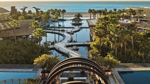 A resort with multiple swimming pools, palm trees, and a view of the ocean. - Thanksgiving in beautiful San José del Cabo at Grand Mayan one bedroom (San José del Cabo)