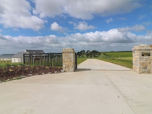 A gated entrance with a stone wall and a sign reading 'Estuary Bliss.' - Radharc an Hook @ Estuary Bliss (Duncannon)