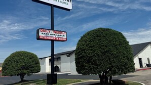 A sign for Homestay Inn & Suites with a daily/weekly rate, free WiFi & cable, and a kitchenette room. - HomeStay Inn & Suites (Oklahoma City)